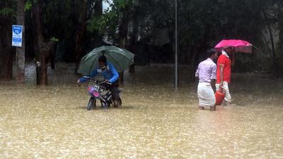 Pedestrians navigate their way through a waterlogged stretch near Galleria Market. (Vipin Kumar/HT PHOTO) Pedestrians navigate their way through a waterlogged stretch near Galleria Market. (Vipin Kumar/HT PHOTO)