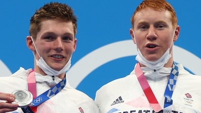 Tom Dean of Britain (right) and Duncan Scott (left) of Britain pose with their gold and silver medal that they won in the men's 200m freestyle swimming event at the Tokyo Olympics. (REUTERS)