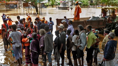 NDRF team distribute food to the people affected by floods caused by the waters discharged from the Koyna dam due to the overflowing of Krishna river in Sangli, India, on Monday, July 26, 2021. (Photo by Uday Deolekar/HT Photo)