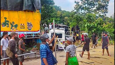Locals near damaged security force vehicles after Monday’s clashes on the Assam-Mizoram border at Lailapur in Cachar district on Tuesday, July 27. (PTI)
