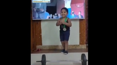 The image shows the little girl imitating Mirabai Chanu. (Twitter@imsathisholy)