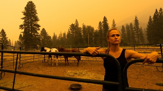 A resident waits for a trailer to evacuate horses at a ranch along State Route 89 during the Dixie Fire in Crescent Mills, California on July 24. At more than 221 square miles in size, the Dixie Fire is now the largest wildfire in California(David Odisho / Bloomberg)