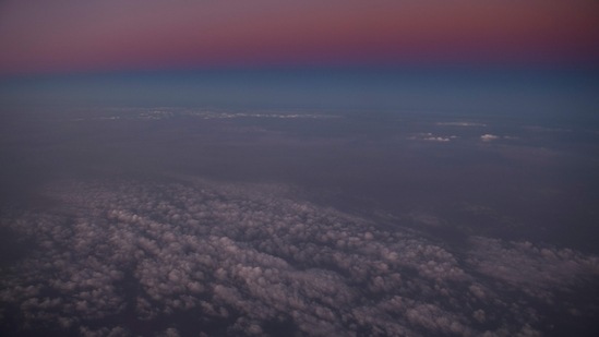 A haze of wildfire smoke and clouds is seen at sunset in an aerial image taken during a flight from Seattle to Los Angeles as western wildfires including the Bootleg, Dixie, and Tamarack fire continue to burn in Oregon and California on July 24 near Bend, Oregon.(Patrick T. Fallon / AFP)
