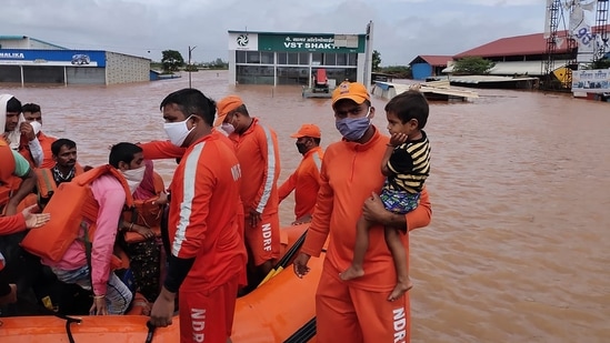 National Disaster Response Force (NDRF) personnel rescuing people from areas inundated with flood waters at Shiroli village in Kolhapur district of Maharashtra.(AFP)