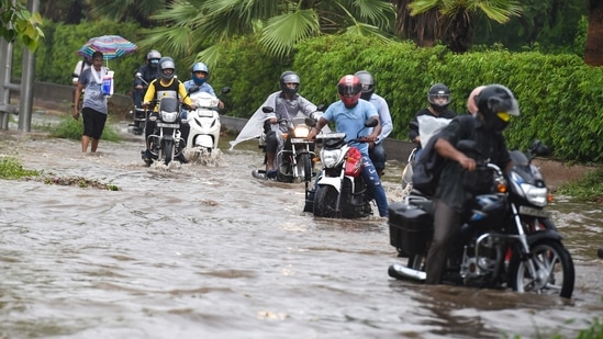 Commuters wade through a waterlogged Ring Road during monsoon rains in New Delhi, Tuesday, July, 27, 2021. (PTI)