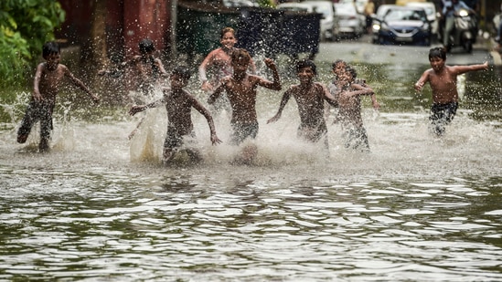 Children play on a waterlogged street after heavy rains near ITO in New Delhi.(PTI)