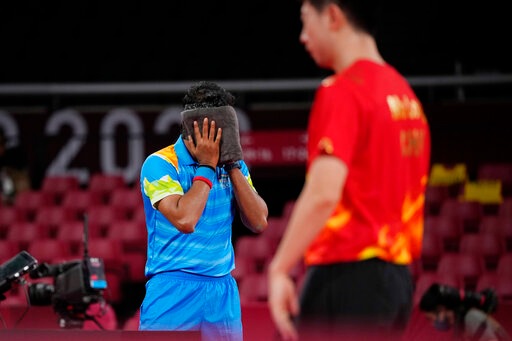 India's Achanta Kamal wipes his face during the table tennis men's singles third round match against China's Ma Long at the 2020 Summer Olympics, Tuesday, July 27, 2021, in Tokyo. (AP Photo/Kin Cheung)