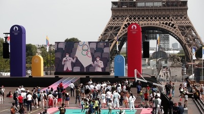 People watch the Tokyo 2020 Olympic Games opening ceremony being displayed on a screen at the Trocadero Gardens, next to the Eiffel Tower, in Paris on July 23. (Benoit Tessier / REUTERS) People watch the Tokyo 2020 Olympic Games opening ceremony being displayed on a screen at the Trocadero Gardens, next to the Eiffel Tower, in Paris on July 23. (Benoit Tessier / REUTERS)