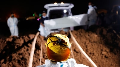 Gravediggers wearing PPE bury a Covid-19 victim on the outskirts of Jakarta, Indonesia. (Reuters)