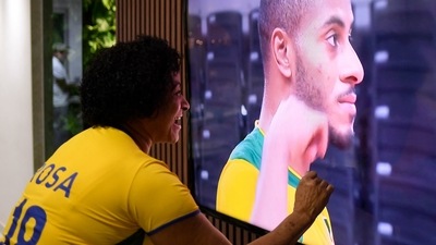 Rosa Maria, mother of Brazilian volleyball player Ricardo Lucarelli, watches on TV while her son participates in the Olympic games, from the family's home in Contagem on July 23. The athlete's family had rented an apartment in Tokyo in 2020, but with the cancellation of the Olympic Games and the ban on the public, they too are following the games from afar. (Douglas Magno / AFP) Rosa Maria, mother of Brazilian volleyball player Ricardo Lucarelli, watches on TV while her son participates in the Olympic games, from the family's home in Contagem on July 23. The athlete's family had rented an apartment in Tokyo in 2020, but with the cancellation of the Olympic Games and the ban on the public, they too are following the games from afar. (Douglas Magno / AFP)