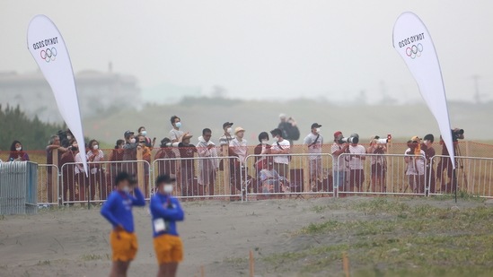 Spectators watch from outside the Tsurigasaki Surfing Beach during Round 3 of Men's Shortboard game in Tokyo on July 26.(Lisi Niesner / REUTERS)