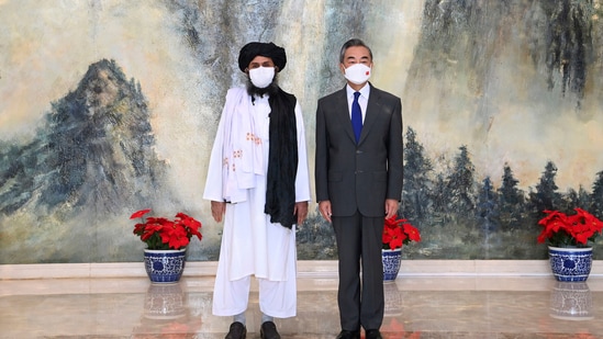 Taliban co-founder Mullah Abdul Ghani Baradar, left, and Chinese Foreign Minister Wang Yi pose for a photo during their meeting in Tianjin, China.(AP)