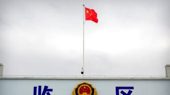 A Chinese national flag flies over a vehicle entrance to the inmate detention area at the Urumqi No. 3 Detention Center in Dabancheng in western China's Xinjiang Uyghur Autonomous Region, on April 23, 2021. (Mark Schiefelbein / AP)