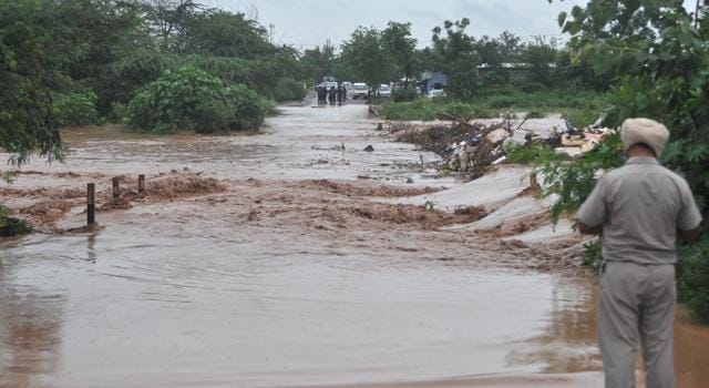 A policeman standing guard near a flooded road in Dadumajra, Chandigarh. (Ravi Kumar/HT) A policeman standing guard near a flooded road in Dadumajra, Chandigarh. (Ravi Kumar/HT)
