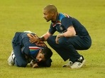 Navdeep Saini holds his arm in pain as Shikhar Dhawan attends during their second Twenty20 cricket match with Sri Lanka in Colombo.(AP) Navdeep Saini holds his arm in pain as Shikhar Dhawan attends during their second Twenty20 cricket match with Sri Lanka in Colombo.(AP)