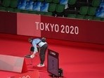 A volunteer wipes official's chair before badminton matches during the Tokyo 2020 Olympic Games