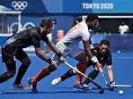 India Harmanpreet Singh is tackled by Argentina's Nahuel Salis (L) and Agustin Alejandro Mazzilli during their men's pool A match of the Tokyo 2020 Olympic Games