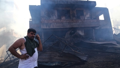 A resident makes a phone call in front of a burnt house in Manavgat. Authorities could not immediately say what caused the fire.  (REUTERS/Kaan Soyturk)