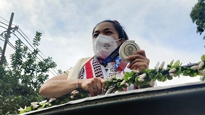Olympic silver medalist weightlifter Mirabai Chanu being welcomed by people as she arrives at the airport, in Imphal on Tuesday. (ANI / Twitter) Olympic silver medalist weightlifter Mirabai Chanu being welcomed by people as she arrives at the airport, in Imphal on Tuesday. (ANI / Twitter)