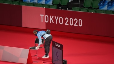 A volunteer wipes official's chair before badminton matches during the Tokyo 2020 Olympic Games (Bloomberg) A volunteer wipes official's chair before badminton matches during the Tokyo 2020 Olympic Games (Bloomberg)