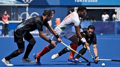 TOPSHOT - India's Harmanpreet Singh (C) is tackled by Argentina's Nahuel Salis (L) and Agustin Alejandro Mazzilli during their men's pool A match of the Tokyo 2020 Olympic Games field hockey competition, at the Oi Hockey Stadium in Tokyo on July 29, 2021. (Photo by JEFF PACHOUD / AFP) (AFP)