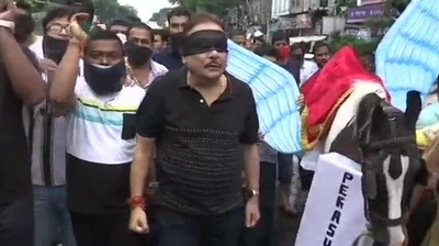 Trinamool Congress leader Madan Mitra walked in the procession blindfolded. (ANI Photo) Trinamool Congress leader Madan Mitra walked in the procession blindfolded. (ANI Photo)