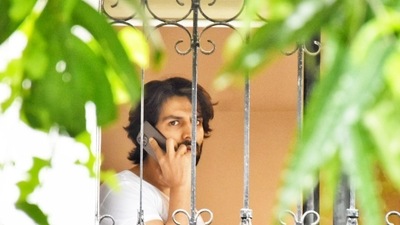 Kartik Aaryan spots photographers from a window. Kartik Aaryan spots photographers from a window.
