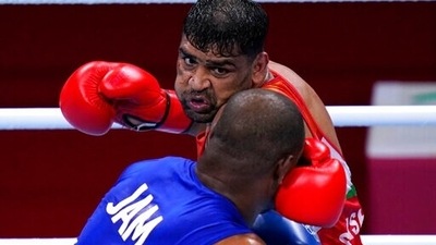 Satish Kumar, top, of India exchanges punches with Ricardo Brown of Jamaica during their men's super-heavy weight 91 kg preliminaries round Boxing match at the 2020 Summer Olympics, Thursday, July 29, 2021, in Tokyo, Japan. (AP Photo/Frank Franklin II) (AP)