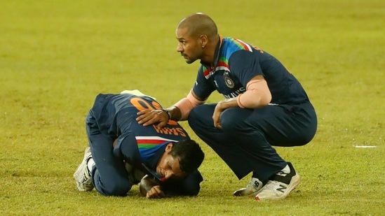 Navdeep Saini holds his arm in pain as Shikhar Dhawan attends during their second Twenty20 cricket match with Sri Lanka in Colombo. (AP)