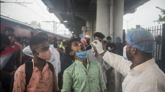 Healthcare worker collects swab samples for Covid-19 test of passengers arriving on outstation trains at Dadar station, in Mumbai. (HT file) Healthcare worker collects swab samples for Covid-19 test of passengers arriving on outstation trains at Dadar station, in Mumbai. (HT file)