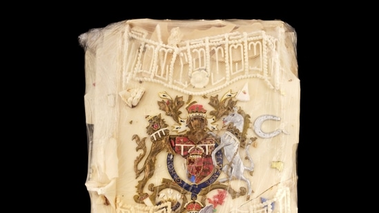 In this photo provided by Dominic Winter Auctioneers, a slice of cake from one of the 23 official wedding cakes made for the Royal Wedding of Britain's Prince Charles and Lady Diana Spencer is seen. It is now up for auction. The cake was given to Moyra Smith, a member of the Queen Mother's household at Clarence House, who preserved the topping with cling film. (Dominic Winter Auctioneers via AP)