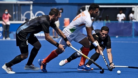 India Harmanpreet Singh is tackled by Argentina's Nahuel Salis (L) and Agustin Alejandro Mazzilli during their men's pool A match of the Tokyo 2020 Olympic Games(AFP)