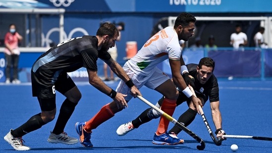 TOPSHOT - India's Harmanpreet Singh (C) is tackled by Argentina's Nahuel Salis (L) and Agustin Alejandro Mazzilli during their men's pool A match of the Tokyo 2020 Olympic Games field hockey competition, at the Oi Hockey Stadium in Tokyo on July 29, 2021. (Photo by JEFF PACHOUD / AFP)(AFP)