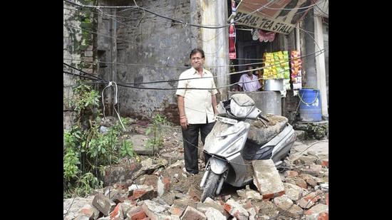 Building owner Ashok Behal standing next to his damaged scooter at the spot where a portion of a building collapsed near Deepak Cinema road in Ludhiana on Thursday. (GURPREET SINGH/HT) Building owner Ashok Behal standing next to his damaged scooter at the spot where a portion of a building collapsed near Deepak Cinema road in Ludhiana on Thursday. (GURPREET SINGH/HT)