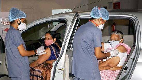 Health workers give a dose of Covid-19 vaccine to elderly women at a drive-in vaccination center in Nagpur. (PTI)