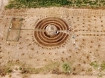 An aerial view of participants of a Tolou Keur programme working on a newly built garden in Boki Diawe, within the Great Green Wall area, in Matam region, Senegal, on July 10, 2021. Gardens known as Tolou Keur hold plants and trees resistant to hot, dry climates, and are planted with circular beds that allow roots to grow inwards, trapping liquids and bacteria and improving water retention and composting.