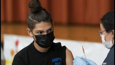 Jesah Hernandez, a student at Lehman High School, gets the Pfizer Covid-19 vaccine from Aylara Geldyeva, in New York. (AP) Jesah Hernandez, a student at Lehman High School, gets the Pfizer Covid-19 vaccine from Aylara Geldyeva, in New York. (AP)