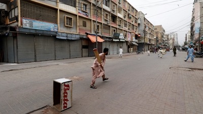 Shopkeepers play cricket along closed market during a partial lockdown after Sindh provincial government decided to shut markets. (Reuters)