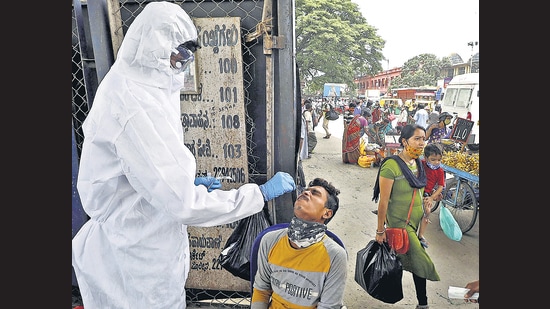 A health worker collects swab sample of a man for Covid-19 test in Bengaluru on Friday. (PTI) A health worker collects swab sample of a man for Covid-19 test in Bengaluru on Friday. (PTI)