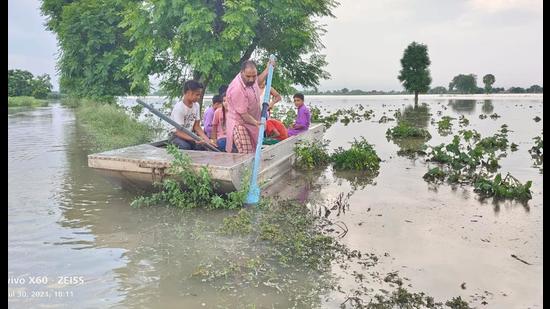 A farmer uses a boat in his submerged fields in Moonak on Friday. (HT Photo)