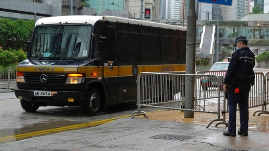 A prison van arrives as a police officer stands guard for Tong Ying-kit's arrival at the Hong Kong High Court in Hong Kong Friday, July 30, 2021. Tong was convicted Tuesday of inciting secession and terrorism for driving his motorcycle into a group of police officers during a July 1, 2020, pro-democracy rally while carrying a flag bearing the banned slogan, "Liberate Hong Kong, revolution of our times." Tong, 24, will be sentenced Friday, the court announced. (AP Photo/Vincent Yu)(AP)