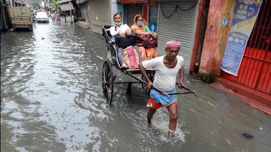 A rickshaw puller carries passengers on a waterlogged road in Kolkata. (File photo)