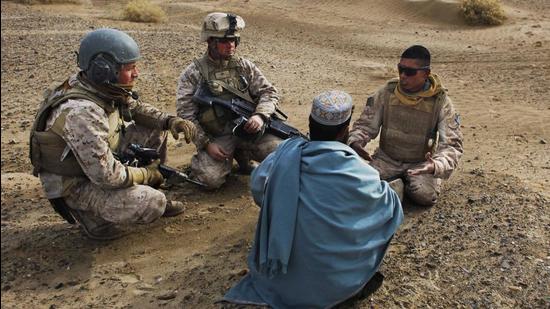 In this December 11, 2009 photo, United States Marine Sgt Isaac Tate (left) and Cpl Aleksander Aleksandrov (centre), interview a local Afghan man with the help of a translator from the 2nd MEB, 4th Light Armoured Reconnaissance Battalion on a patrol in the Helmand province of southern Afghanistan. (AP)
