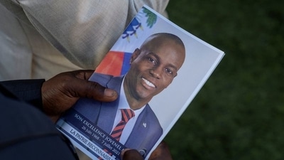 A person holds a photo of late Haitian President Jovenel Moise, who was shot dead earlier this month, during his funeral at his family home in Cap-Haitien, Haiti. (Reuters)