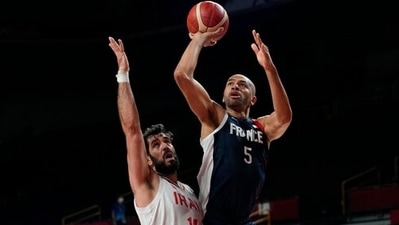 France's Nicolas Batum (5), right, shoots over Iran's Mohammadsamad Nik Khahbahrami (14) during men's basketball preliminary round game at the 2020 Summer Olympics, Saturday, July 31, 2021, in Saitama, Japan. (AP Photo/Eric Gay) (AP)