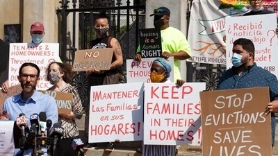 People from a coalition of housing justice groups hold signs protesting evictions in Boston. (AP) People from a coalition of housing justice groups hold signs protesting evictions in Boston. (AP)