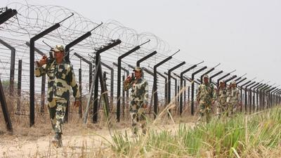 Border Security Force personnel patrolling the fence along the border with Pakistan in Punjab’s Tarn Taran district. (Sameer Sehgal/HT file photo)