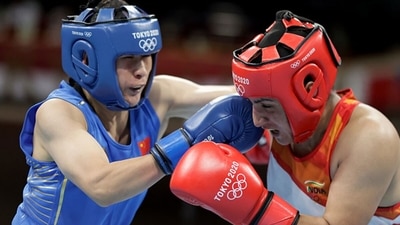 Pooja Rani (red) of India exchanges punches with Qian Li of China. (Getty Images)