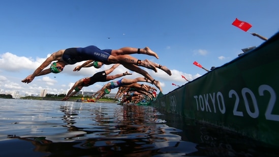 Katie Zaferes, front, drives in to the water during the mixed relay triathlon at the 2020 Summer Olympics, Saturday, July 31, 2021, in Tokyo, Japan. (Antonio Bronic/Pool Photo via AP)(AP)