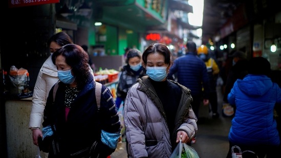 People wearing face masks walk on a street market, following an outbreak of the coronavirus disease in Wuhan, China.(Reuters File Photo)